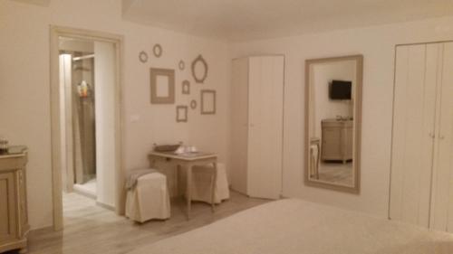 Habitación blanca con mesa y espejo. en Novecento Charming Room, en Avigliana