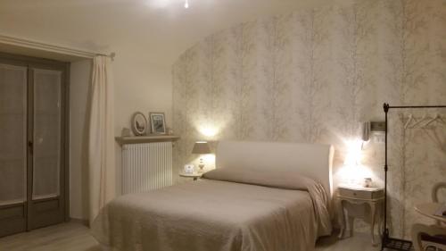 a bedroom with a bed and two tables and two lamps at Novecento Charming Room in Avigliana