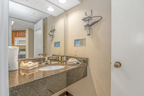 La salle de bains est pourvue d'un lavabo et d'un miroir. dans l'établissement Oceanview 1 Bedroom Suite Landmark Resort 548 Perfect for a couple or party of 4, à Myrtle Beach