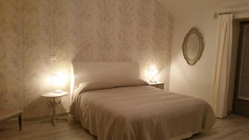a bedroom with a bed and two tables with lamps at Novecento Charming Room in Avigliana