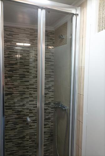 a shower with a glass door in a bathroom at Zeta ' s house in Nafpaktos