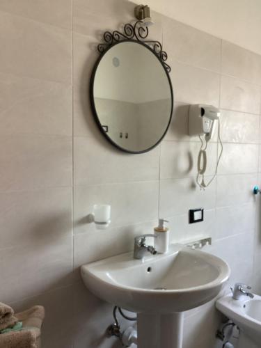 uma casa de banho com um lavatório e um espelho na parede em LA STELLA DELLE DOLOMITI em Pedavena