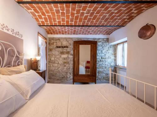 1 dormitorio con 1 cama grande y pared de piedra en Casa Domenica - Home&more, en Monastero Bormida