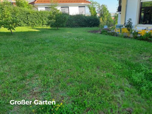 a yard with a green field of grass and a house at Designpension Idyll Nr2 Hotel Garni in Wernigerode