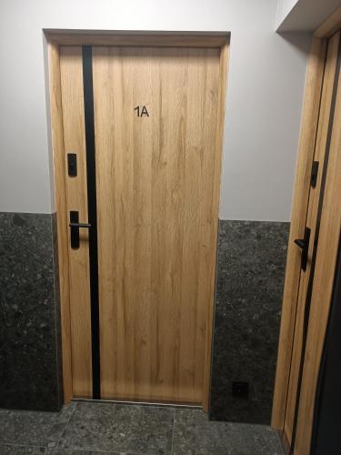 a wooden door with the word la on it at FLATMORE Apartament Akacjowa 17m1A in Zielona Góra