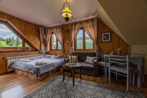 a bedroom with a bed and a couch and windows at Vila Panorama in Ždiar