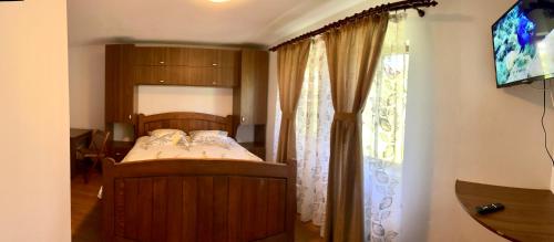 - une chambre avec un lit et une fenêtre dans l'établissement Casa de sub Salcie, à Curtea de Argeş