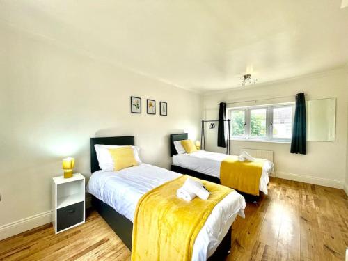 a bedroom with two beds and a window at Modern 3 Bed Romford Home (Free Parking) in Havering atte Bower