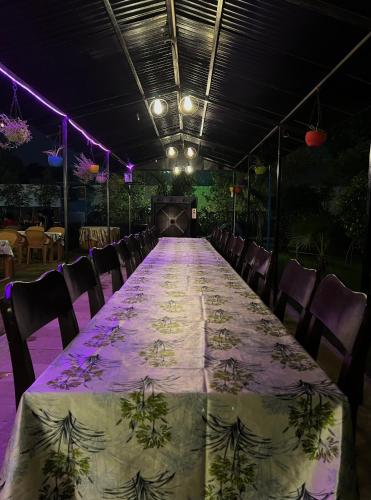 a long table in a room with chairs and lights at Agra Camps and Resort in Agra
