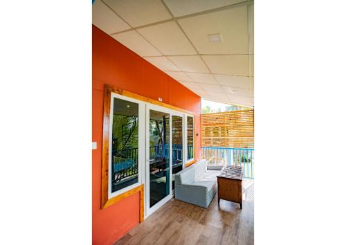 a living room with an orange wall and a couch at orange sky beach bungalow in Agonda