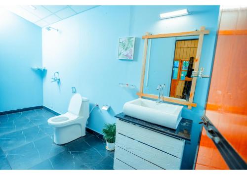 a blue bathroom with a toilet and a sink at orange sky beach bungalow in Agonda
