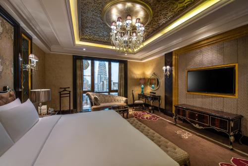 Narcissus Riyadh Hotel & Spa في الرياض: غرفة نوم بسرير وتلفزيون بشاشة مسطحة
