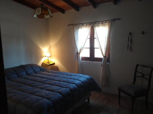 a bedroom with a blue bed and a window at Villa Escondida in Mar del Plata