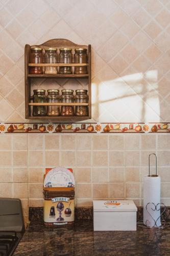 a kitchen with a counter top with jars on a shelf at Cabañas Morada del Cerro -Cabaña Algarrobo- in Capilla del Monte