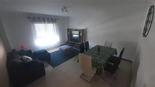 uma sala de estar com uma mesa e uma televisão em GreenSea em Peniche