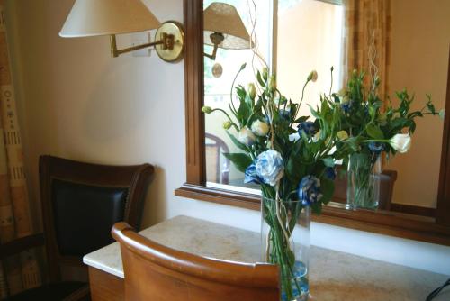 利馬索爾的住宿－M. 莫尼阿提斯酒店，坐在镜子前的桌子上的花瓶