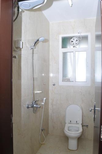 łazienka z toaletą, prysznicem i oknem w obiekcie Aknan 01 - Center Market w mieście Salala