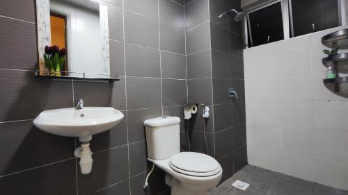 La salle de bains est pourvue de toilettes et d'un lavabo. dans l'établissement A ONE Holiday Apartment-Quintet, à Cameron Highlands