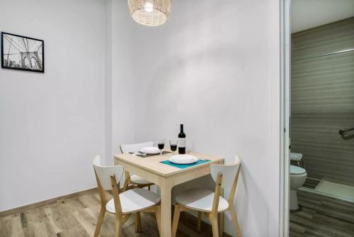 a dining room with a table and chairs and a toilet at Umihouse apartamentos centro Alicante in Alicante