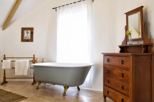 a bathroom with a white tub and a dresser at Kogman & Keisie Guest Farm in Montagu