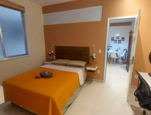 ein Schlafzimmer mit einem Bett mit einer orangefarbenen Decke in der Unterkunft Studio da Babi in Rio de Janeiro