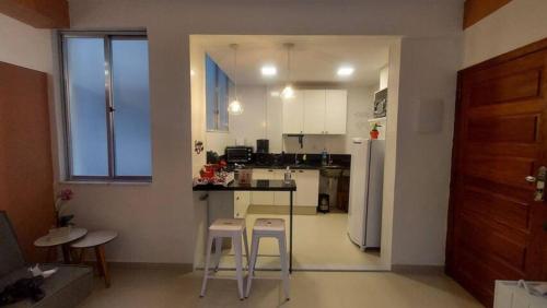 - une cuisine avec un comptoir et des tabourets dans une pièce dans l'établissement Studio da Babi, à Rio de Janeiro