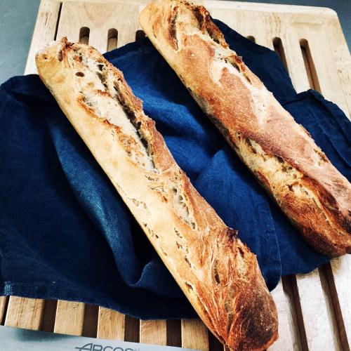 two loaves of bread sitting on a cutting board at Aubépine in Sains-du-Nord