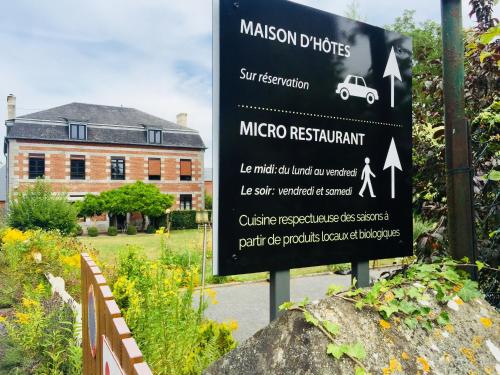 a sign in front of a building with a car on it at Aubépine in Sains-du-Nord