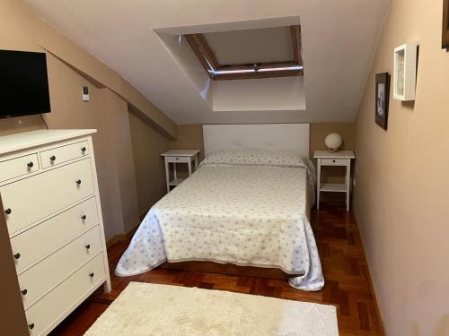 a small bedroom with a bed and a tv at Sweet Home in Moaña