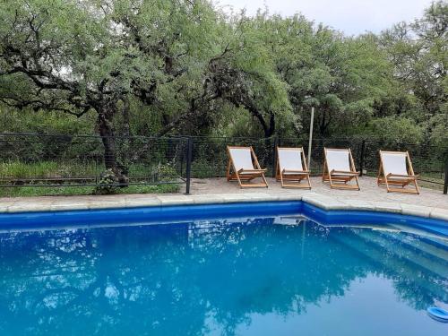 a group of chairs sitting next to a swimming pool at Indigo in Carpintería