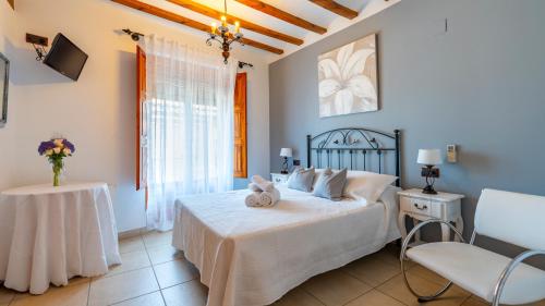 a bedroom with a bed and a table and a chair at Hotel El Rullo in Vilafamés