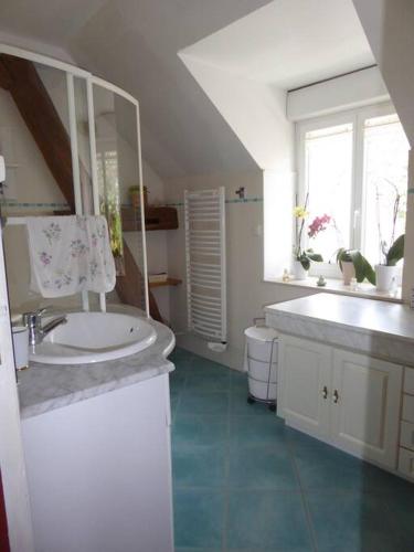 une salle de bain blanche avec un lavabo et un miroir dans l'établissement Maison entière indépendante ( logement 1 ), à Noyers-sur-Serein