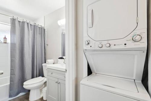 a white bathroom with a toilet and a mirror at Viridian Biltmore Villa with Pool in Phoenix