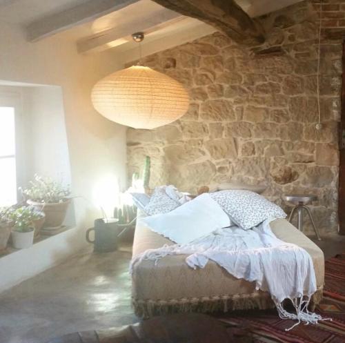 1 dormitorio con cama y pared de piedra en Podere Relais Fabilandia, en Tolè