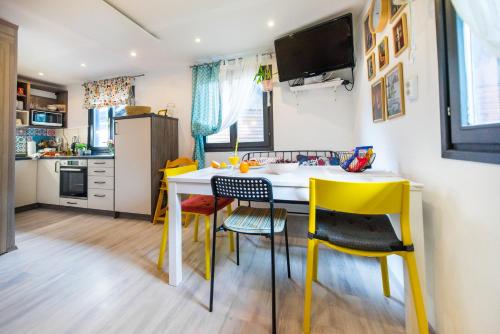 a small kitchen with yellow chairs and a white table at Boho House 2 in camp Terme Catez in Čatež ob Savi