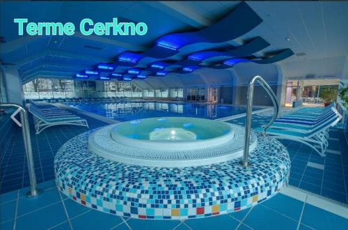 a swimming pool with a hot tub in a building at Brunarica Jeršin in Cerkno