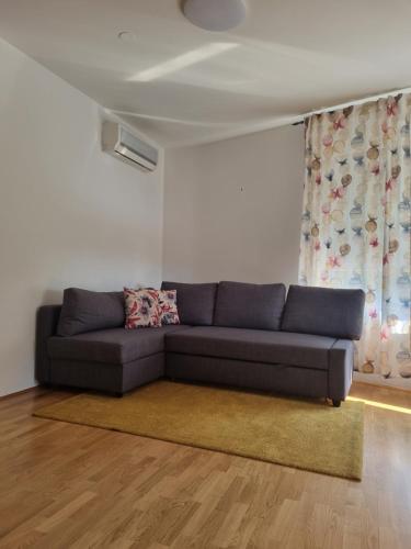 a living room with a blue couch in front of a window at Apartman Fran in Zagreb