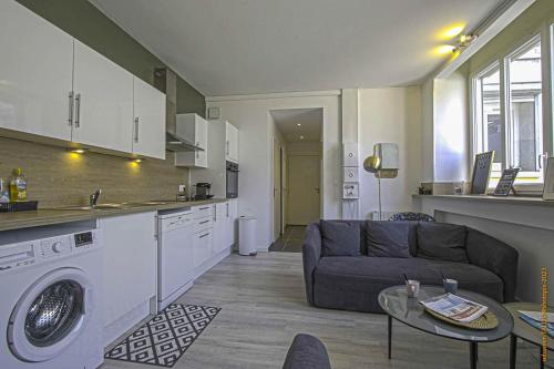 Il dispose d'une cuisine et d'un salon avec un canapé et une table. dans l'établissement CosyRouen bouquet parking gratuit, à Rouen