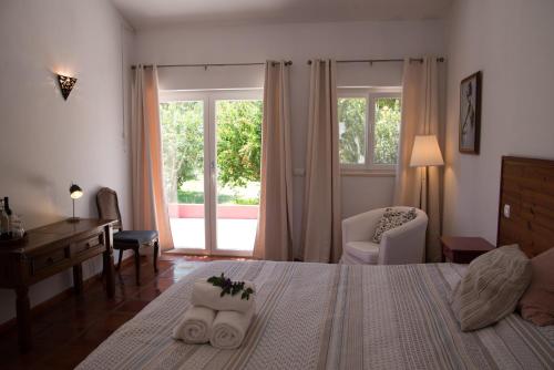 um quarto com uma cama, uma secretária e uma janela em Casa Spa d'Alma em Monchique