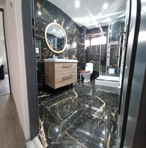 a bathroom with a marble floor and a mirror at Privát Alenka in Važec