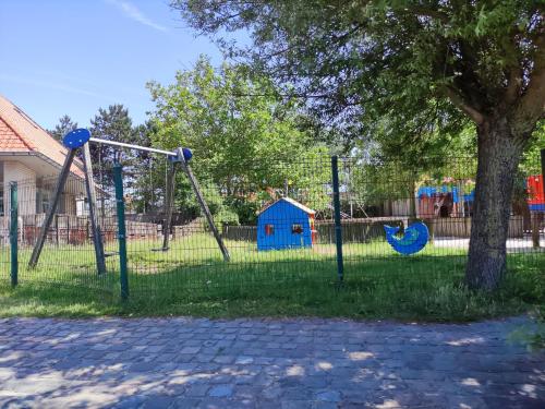 a playground with two swings and a tree at Camping Urlaub Bredene Belgien in Bredene