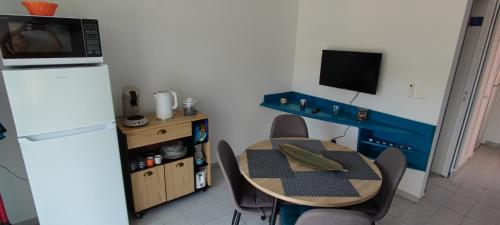 a small kitchen with a table and a refrigerator at TOUMALACAÏ Appart 238 in Folle Anse