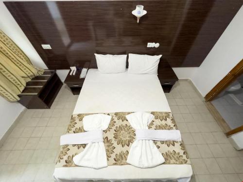 - une chambre avec un grand lit et des draps blancs dans l'établissement Grand Atlas Pansiyon, à Pamukkale