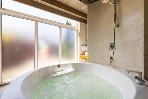 a bath tub with water in it next to a window at Cube house in Pärnu