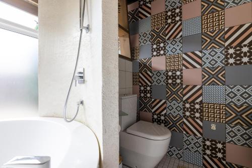 a bathroom with a toilet and a tile wall at Cube house in Pärnu