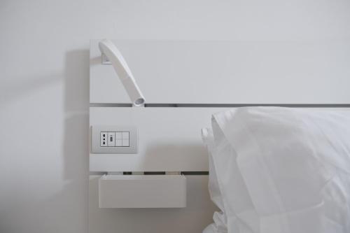 a bed with a light next to a pillow and a lightswitch at Supernova in Savona
