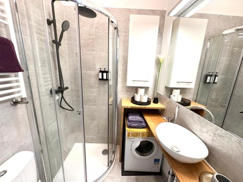 La salle de bains est pourvue d'une douche, d'un lavabo et d'un lave-linge. dans l'établissement Cozy city Apartment close to metro - Self Check-in, à Vienne