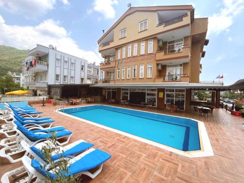 een hotel met ligstoelen en een zwembad bij Marina Apart Hotel in Marmaris