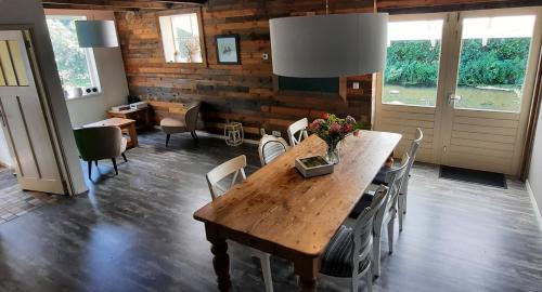 a dining room with a wooden table and chairs at Rustiek Andijk in Andijk