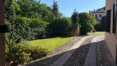 a garden with a walkway and a lawn with bushes at Regina dei fiori in Marostica